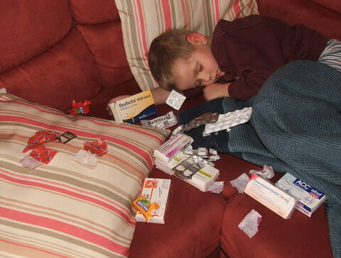 Kindernotfallseminar Bild krankes Kind Sofa Medikamente